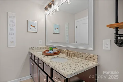 a bathroom with a granite countertop sink and a mirror