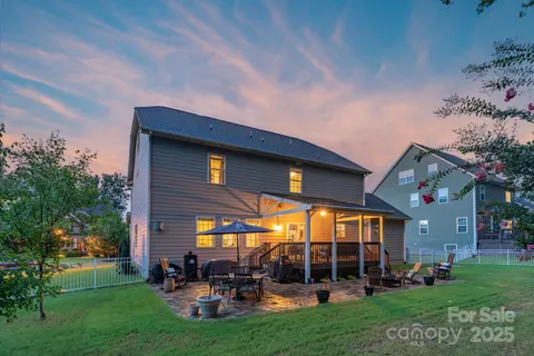a view of a patio with table and chairs potted plants and large tree