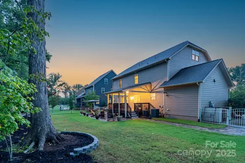 a view of a backyard with potted plants and large tree
