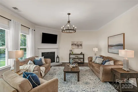 a living room with furniture a fireplace and a chandelier