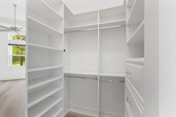 a view of walk in closet with empty racks