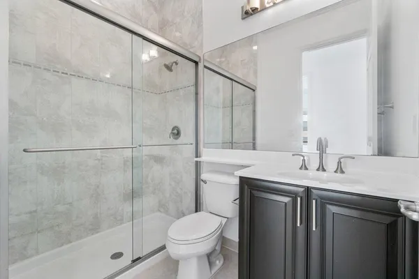 a bathroom with a granite countertop sink toilet and shower