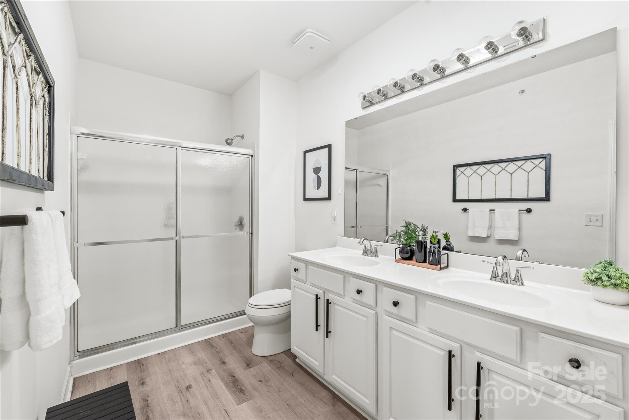 12357 Copper Mountain Boulevard Charlotte, NC 28277 - Photo 17 of 36 a bathroom with a double vanity sink mirror and toilet