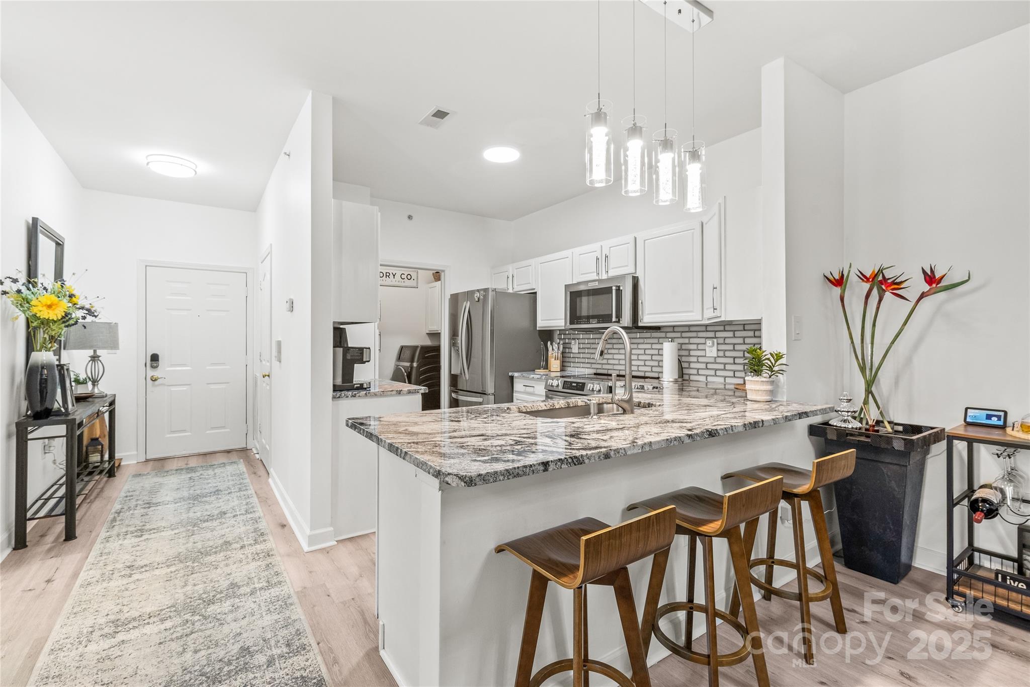 12357 Copper Mountain Boulevard Charlotte, NC 28277 - Photo 4 of 36 a kitchen with stainless steel appliances kitchen island granite countertop a table chairs in it and wooden floors