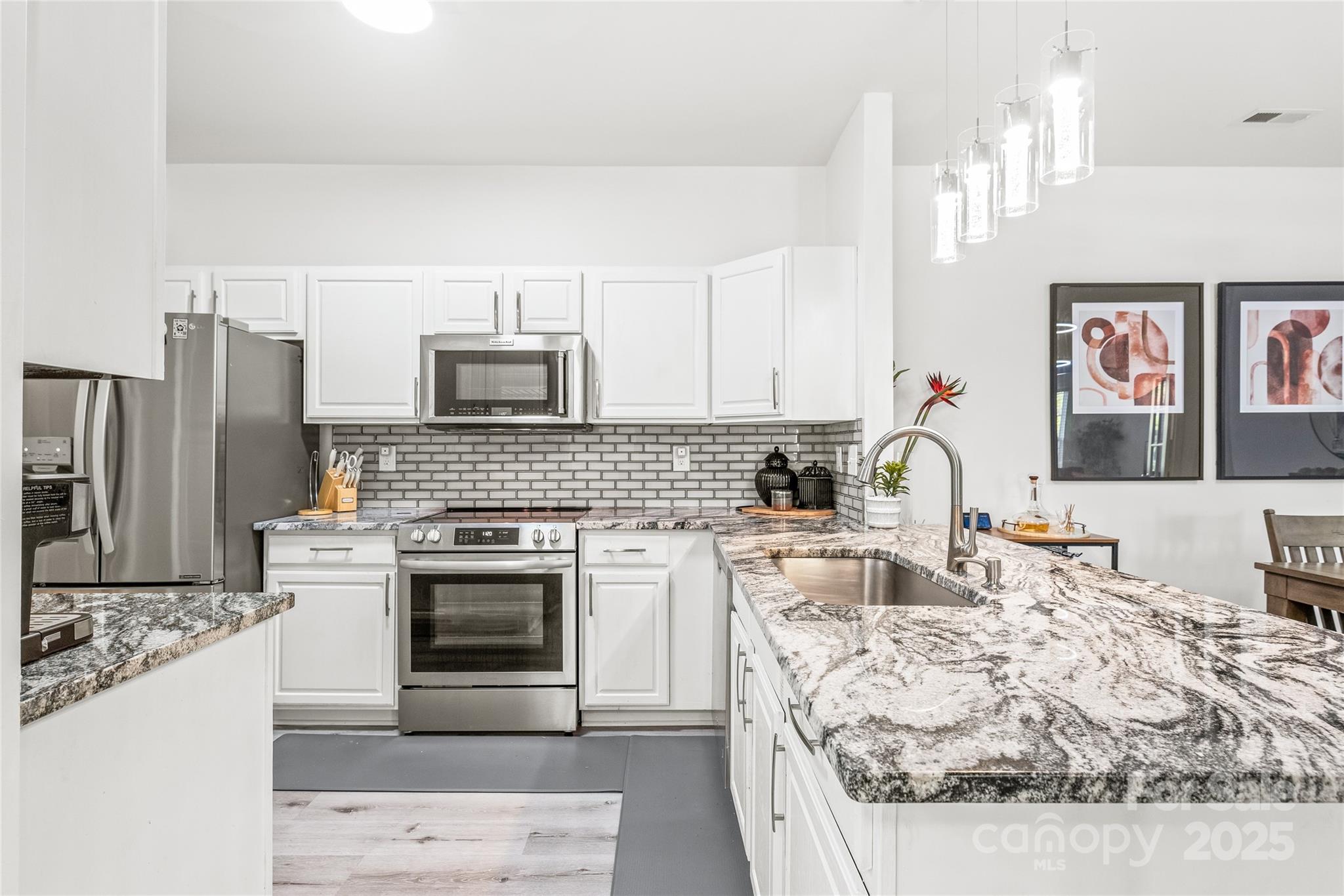 12357 Copper Mountain Boulevard Charlotte, NC 28277 - Photo 6 of 36 a kitchen with stainless steel appliances granite countertop a stove top oven a sink and a refrigerator