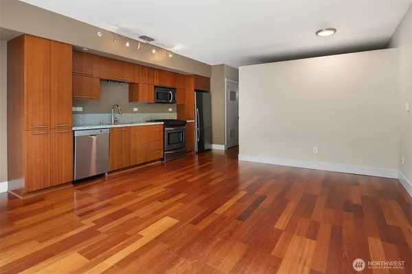 a view of a kitchen with wooden floor and electronic appliances