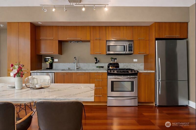 2911 2nd Avenue, Unit 310 Seattle, WA 98121 - Photo 5 of 40 a kitchen with stainless steel appliances a stove a sink and a refrigerator