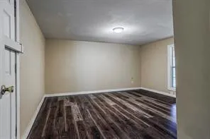 a view of a room with wooden floor and white walls