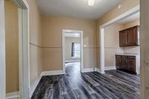 a view of a hallway with wooden floor and a fireplace