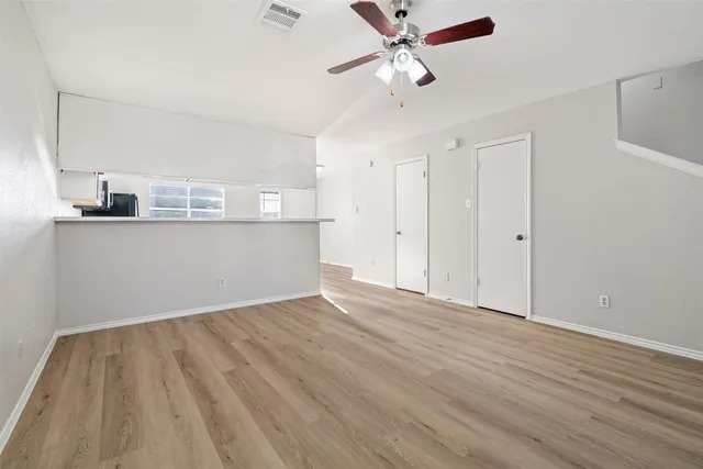 a view of a kitchen with wooden floor and a ceiling fan