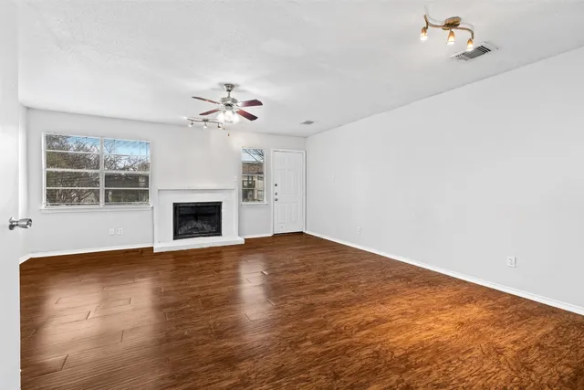 a view of an empty room with a fireplace and a window