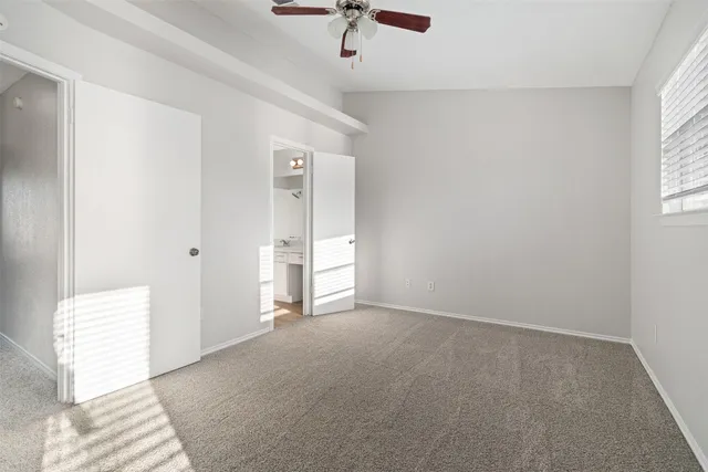 an empty room with fan and windows