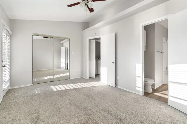 a view of an empty room with window and bathroom