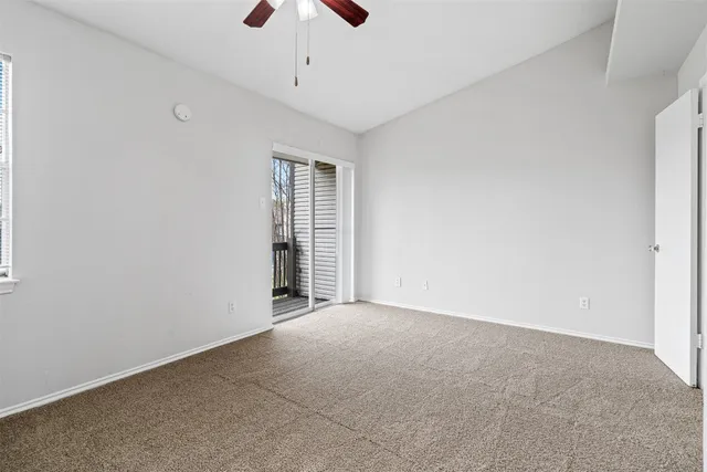 an empty room with chandelier fan