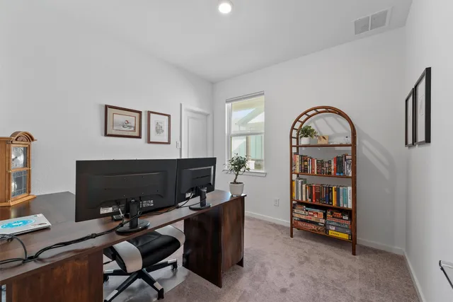 a view of a workspace with furniture and a window