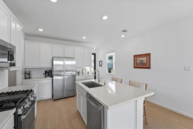 a kitchen that has a lot of cabinets a sink and appliances