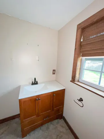 a living room with a sink and a large mirror next to a window