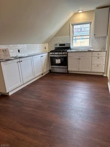 a kitchen with granite countertop white cabinets and white appliances