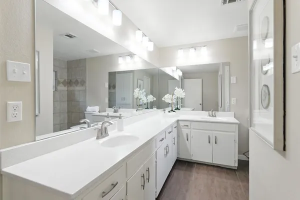 a spacious bathroom with a double vanity sink and mirror