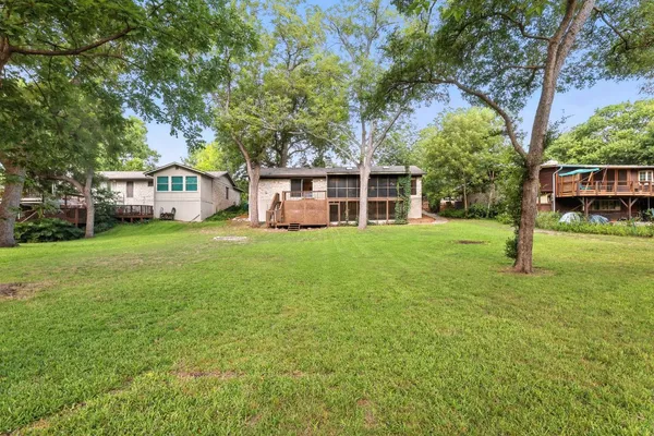 a view of a house with a big yard and large trees
