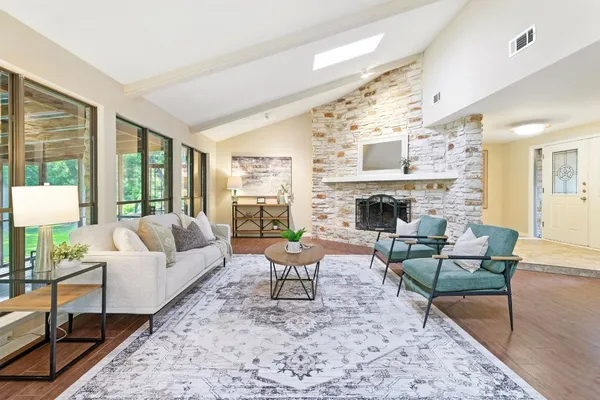 a living room with furniture fireplace and a large window
