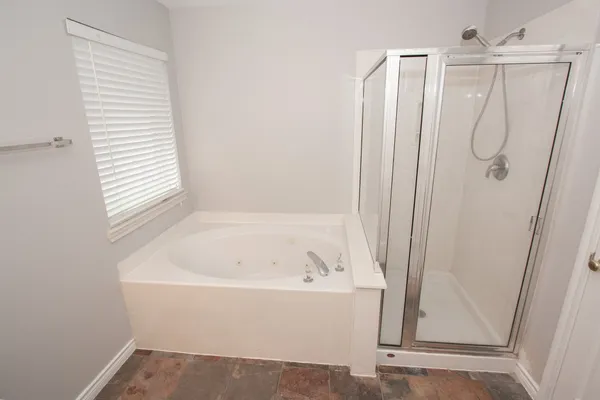 a white bath tub sitting next to a shower