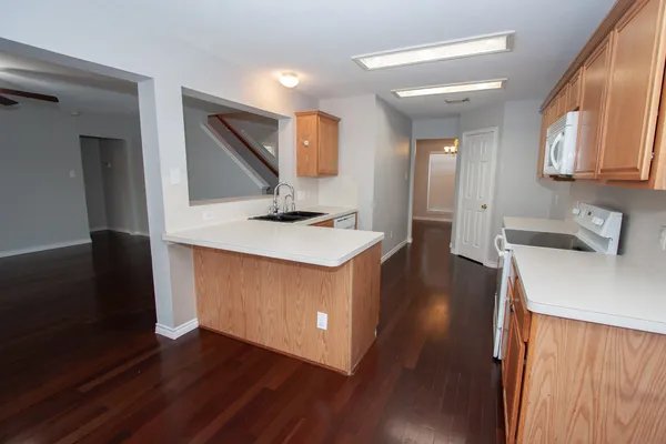 a kitchen with kitchen island a sink stove and wooden floor
