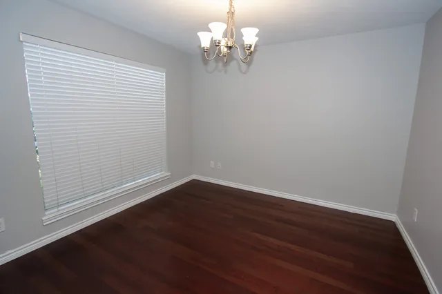 a view of a room with wooden floor and chandelier