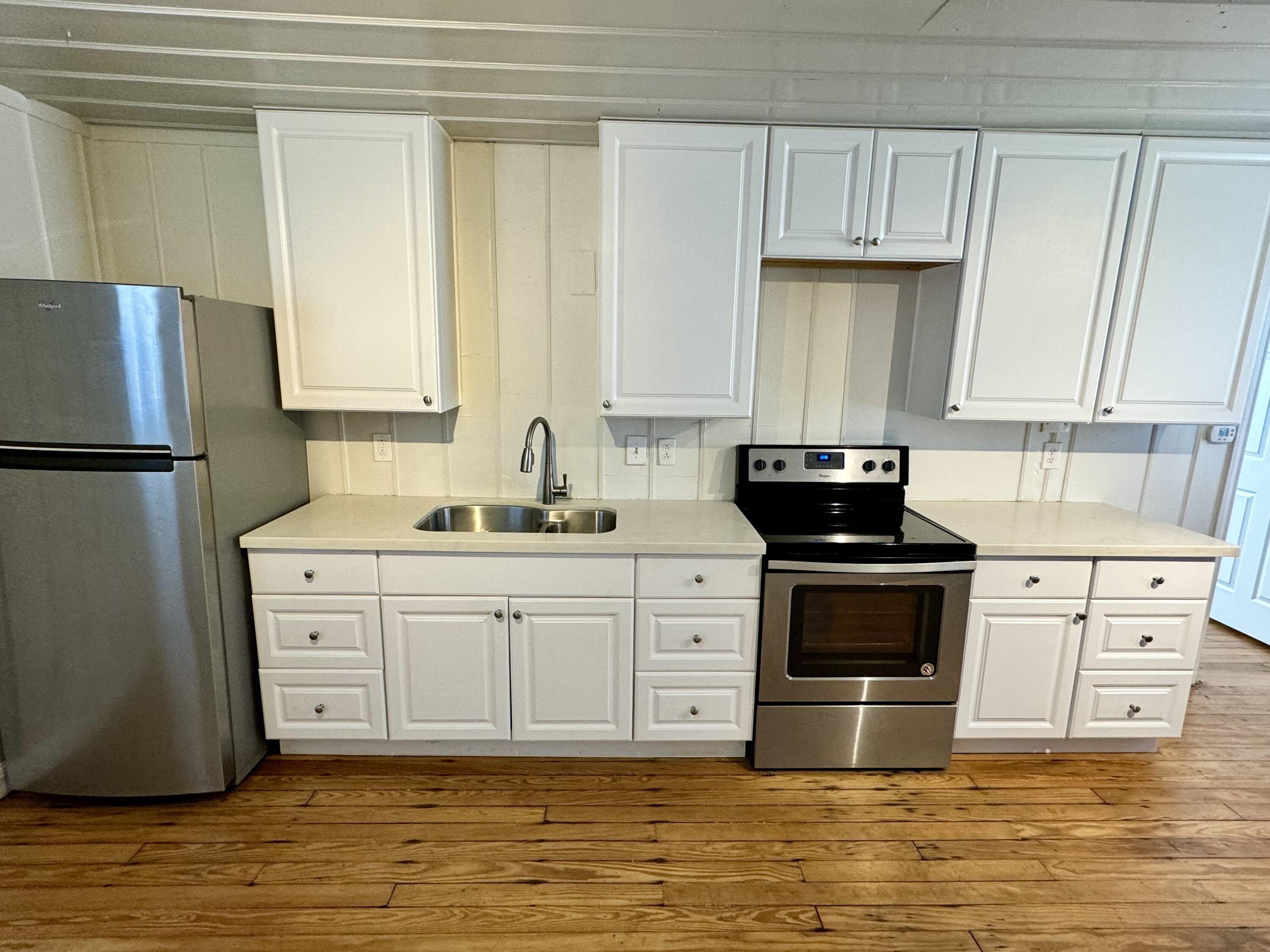 2107 14th Street, Unit B Lubbock, TX 79401 - Photo 2 of 6 a kitchen with stainless steel appliances a stove a sink and white cabinets