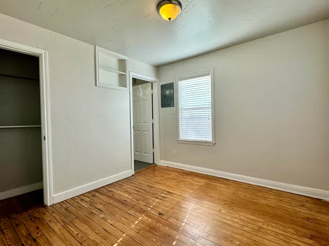 an empty room with wooden floor and window
