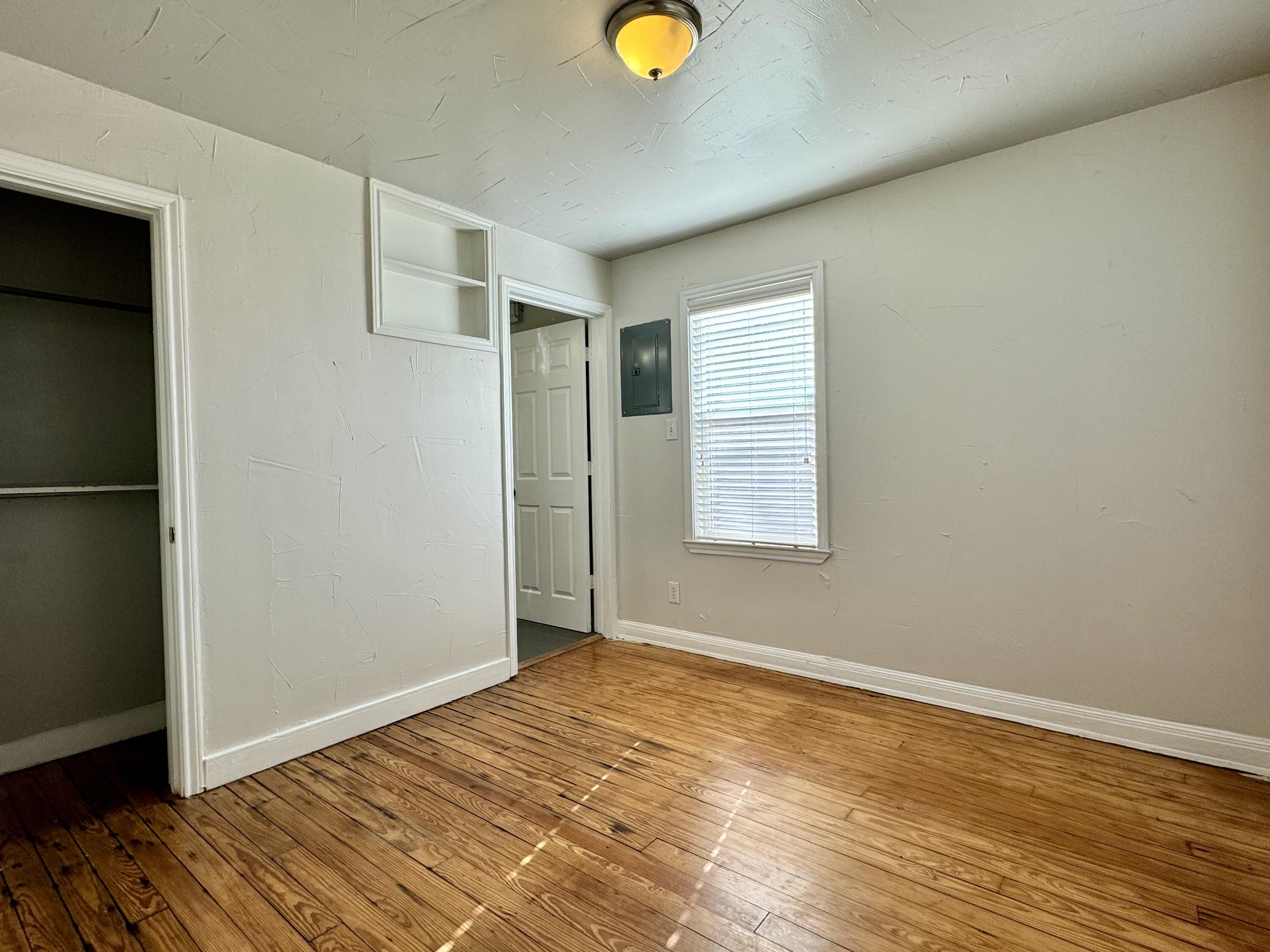 2107 14th Street, Unit B Lubbock, TX 79401 - Photo 3 of 6 an empty room with wooden floor and window