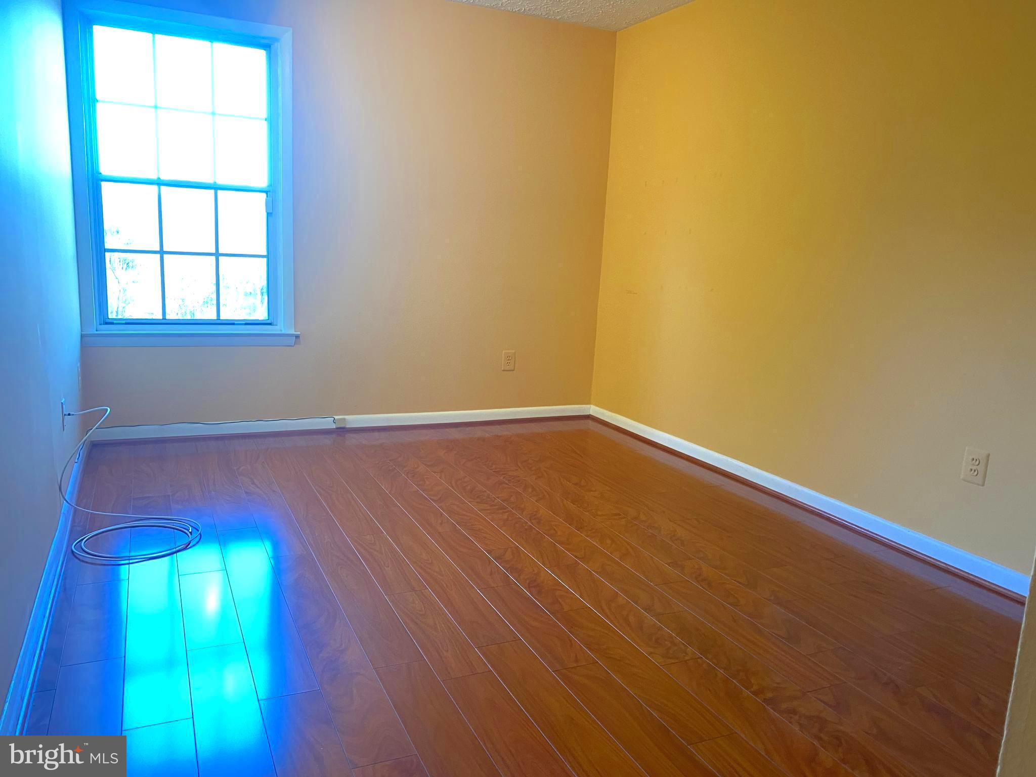 2109 B Woodbox Lane, Unit 2109B Baltimore, MD 21209 - Photo 11 of 26 an empty room with a window and wooden floor