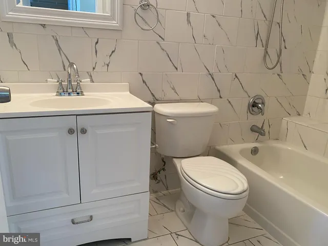 a bathroom with a sink a toilet and bathtub