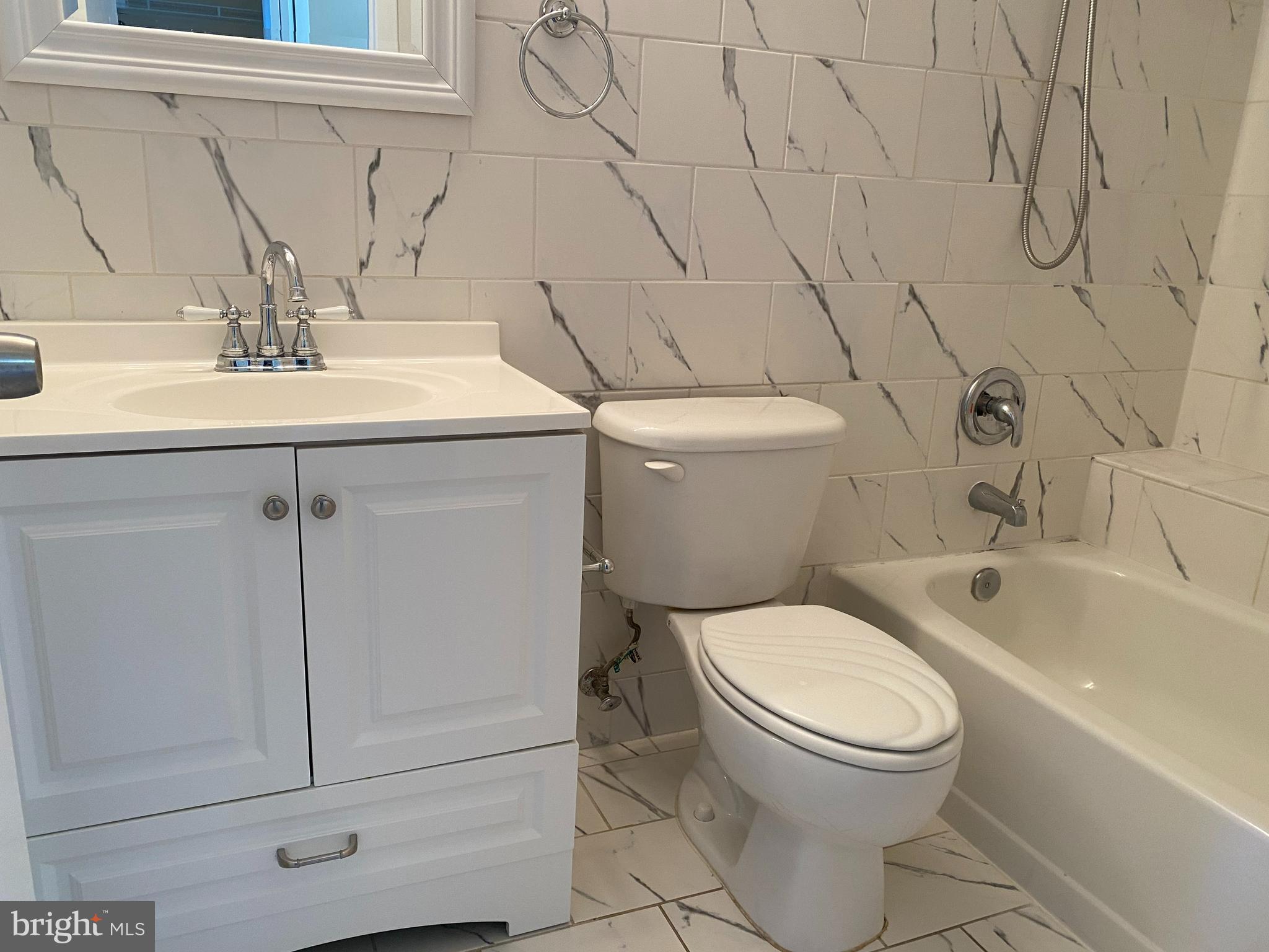 2109 B Woodbox Lane, Unit 2109B Baltimore, MD 21209 - Photo 19 of 26 a bathroom with a sink a toilet and bathtub