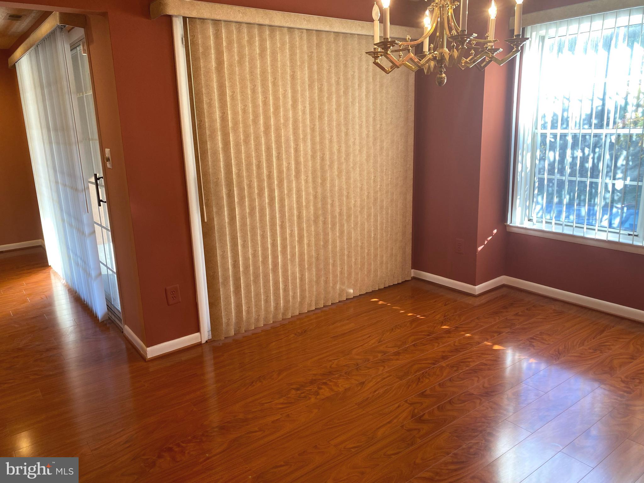 2109 B Woodbox Lane, Unit 2109B Baltimore, MD 21209 - Photo 7 of 26 an empty room with wooden floor and windows