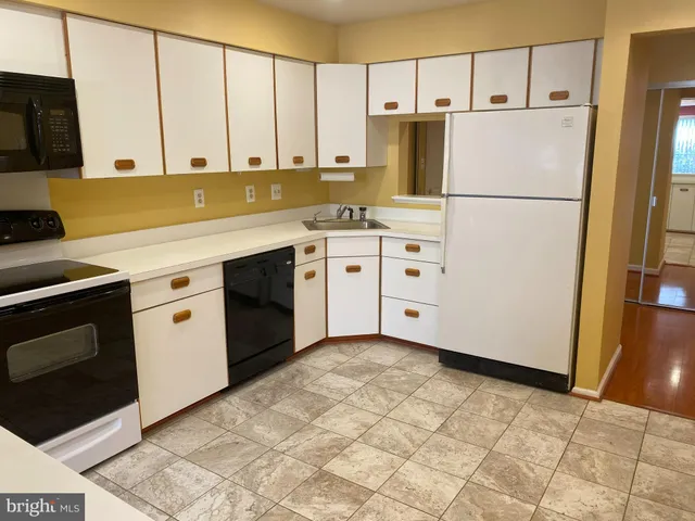a kitchen with appliances cabinets and wooden floor