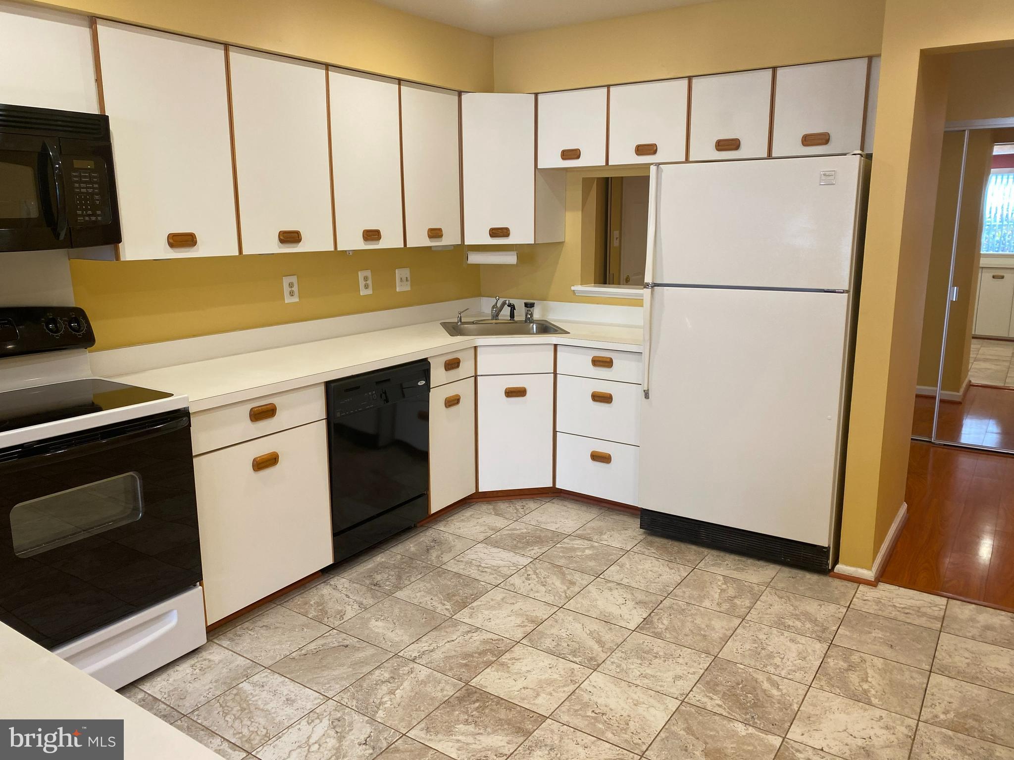 2109 B Woodbox Lane, Unit 2109B Baltimore, MD 21209 - Photo 9 of 26 a kitchen with appliances cabinets and wooden floor