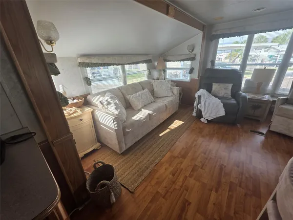 a living room with furniture and a wooden floor