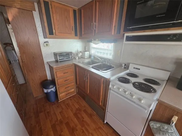 a kitchen with a sink a stove and cabinets