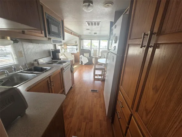 a kitchen with sink refrigerator and wooden floor