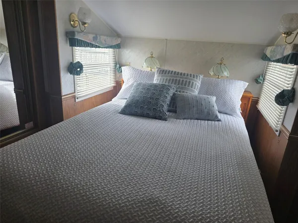 a large bed sitting in a bedroom next to a window