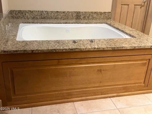 a bathroom with a granite countertop sink and white cabinets