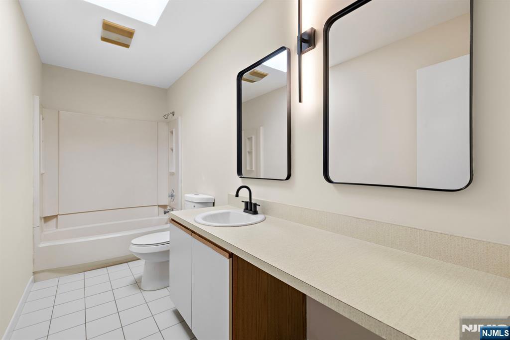 319 Gorge Road, Unit 6 Cliffside Park, NJ 07010 - Photo 15 of 24 a bathroom with a double vanity sink mirror and toilet