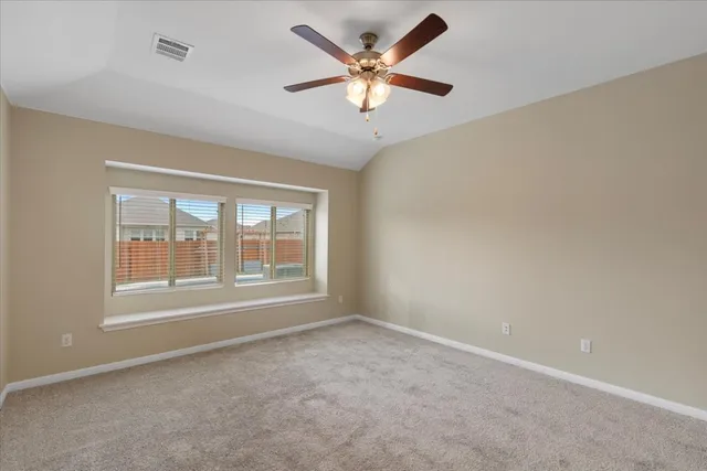 an empty room with a window and a ceiling fan