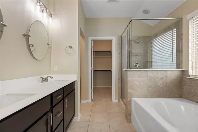 a bathroom with a tub sink and mirror