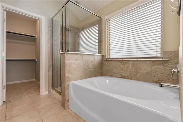a white bath tub sitting in a bathroom next to a window