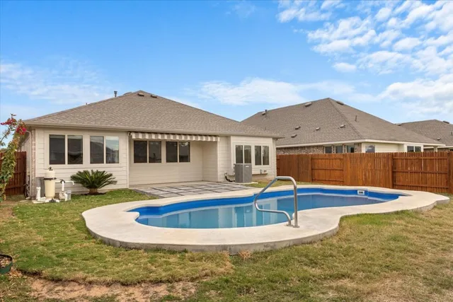 a view of a house with pool and a yard