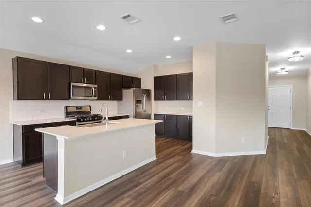 a kitchen with stainless steel appliances a microwave sink refrigerator and cabinets