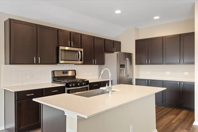 a kitchen with a sink a microwave a stove and refrigerator