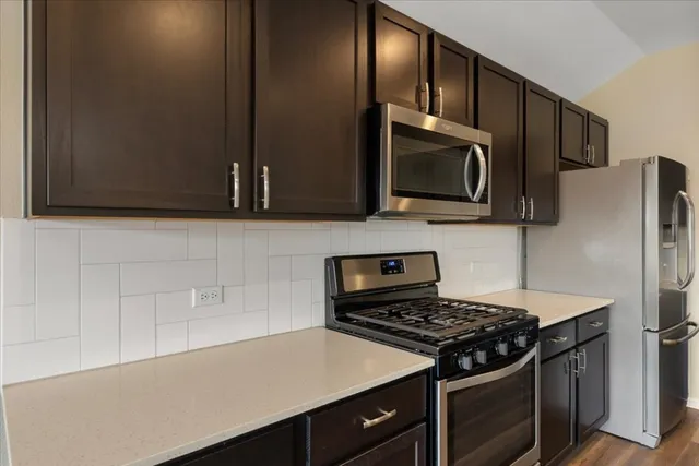 a kitchen with stainless steel appliances wooden cabinets and a stove top oven
